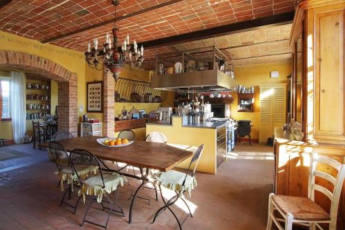 uma sala de jantar com uma mesa e cadeiras numa cozinha em CASCINA BELLAVISTA - Luxury Country Villa + Pool 