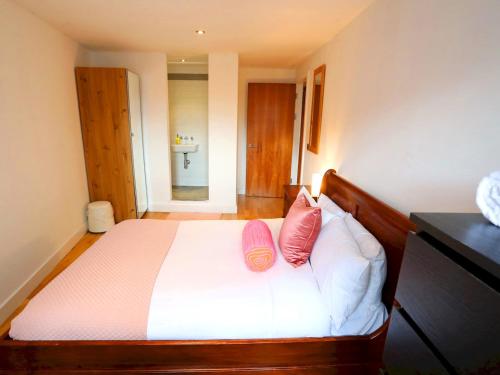 een slaapkamer met een bed met 2 kussens erop bij Pass the Keys Bohemian Ancoats suite with balcony in Manchester