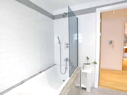 een witte badkamer met een douche en een toilet bij Pass the Keys Bohemian Ancoats suite with balcony in Manchester