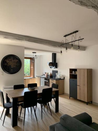 une cuisine et une salle à manger avec une table et des chaises dans l'établissement Location saisonnière à Montours, à Montours