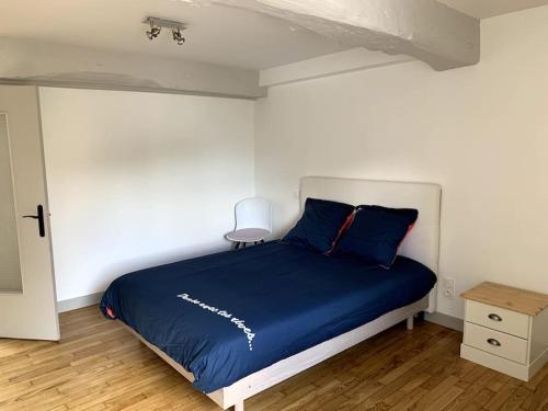 Cette chambre comprend un lit avec des draps bleus et du parquet. dans l'établissement Location saisonnière à Montours, à Montours