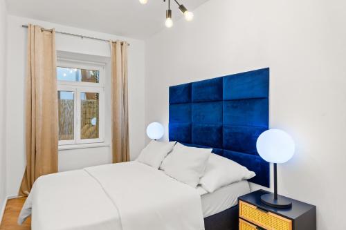 - une chambre avec un lit blanc et une tête de lit bleue dans l'établissement Vienna Chic Residences #Suite 1, à Vienne