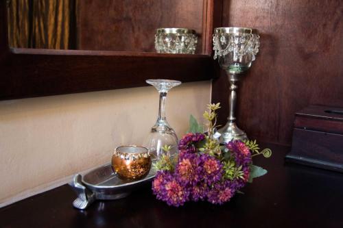 a table with two wine glasses and a bouquet of flowers at Zoete Rust Boutique Hotel in Lephalale