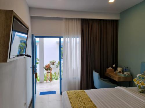 una camera d'albergo con letto, scrivania e porta di Sunnydays homestay a Jepara