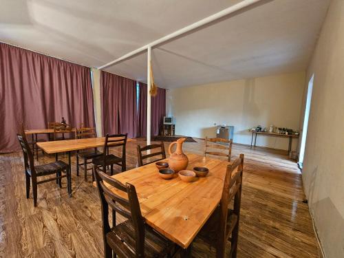 ein Esszimmer mit Holztischen und -stühlen in der Unterkunft Guest House Aleksandre in T'mogvi