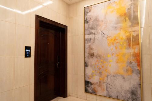 un corridoio con un grande dipinto accanto a una porta di فندق رحيب للشقق المخدومة Rahib Suites a Abha