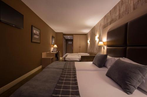 Un pat sau paturi într-o cameră la Hotel Himàlaia Soldeu