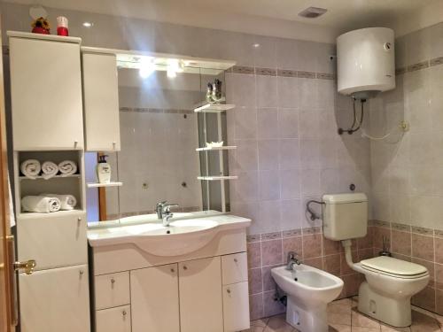 a bathroom with a sink and a toilet and a mirror at Apartment Anima 3 in Klimno