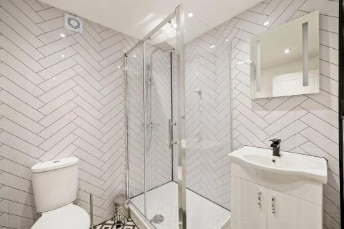 a bathroom with a shower and a toilet and a sink at Stylish Yorkshire Apartment - Sleeps 5 in Castleford