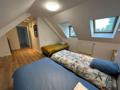um quarto no sótão com 2 camas e uma janela em Magnifique longère au calme em Trégunc