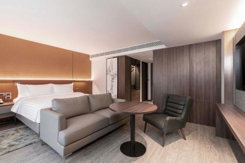 a hotel room with a couch and a bed at Gardina Asoke Hotel & Residence in Bangkok