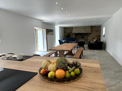 - un bol de fruits sur une table dans le salon dans l'établissement Magnifique longère au calme de Kerminaouet, à Trégunc