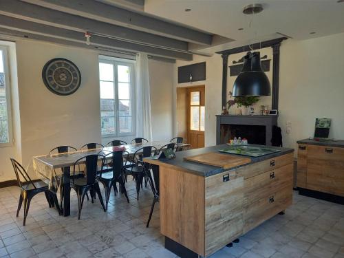 Una cocina y un comedor con mesa y sillas. en Jolie charentaise dans la campagne de saintonge, en Saint-Mandé-sur-Brédoire