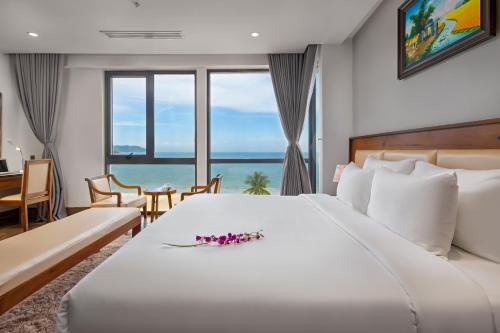 Cette chambre d'hôtel comprend un grand lit et offre une vue sur l'océan. dans l'établissement Alisia Beach Hotel Da Nang, à Đà Nẵng