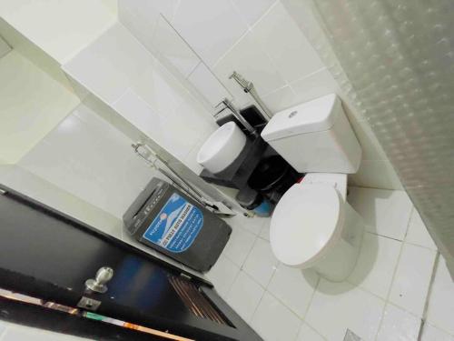 een badkamer met een toilet en een vuilnisbak bij Best Staycation - Kasara De Ulap C5 Pasig in Manilla