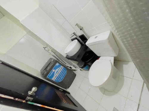 a bathroom with a toilet and a trash can at Kasara De Ulap BEST Staycation - 25th Floor City View - Pool & Fast Wi-Fi in Manila