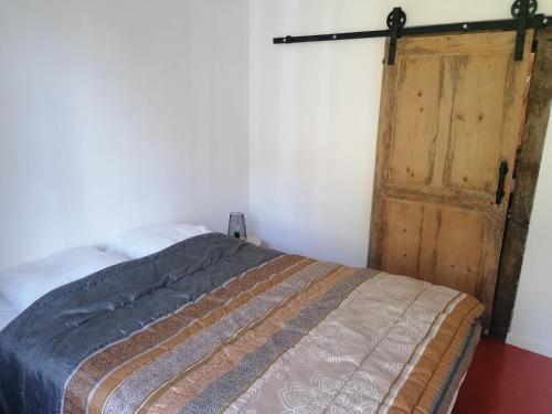 a bedroom with a bed and a wooden door at chez Marie et Lulu in Dompierre-sur-Nièvre