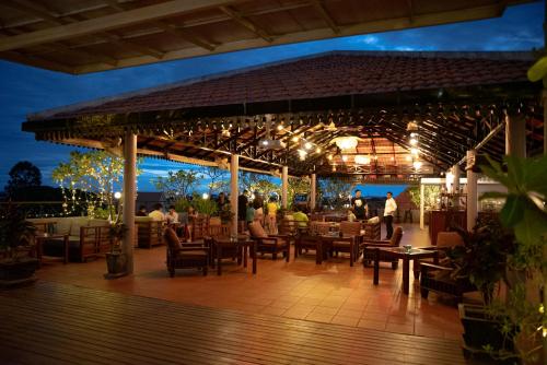 a restaurant with tables and chairs at night at The Suite By Royal Crown Hotel in Siem Reap