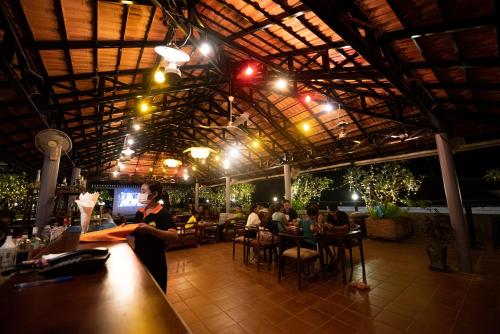 a woman standing at a bar in a restaurant at The Suite By Royal Crown Hotel in Siem Reap