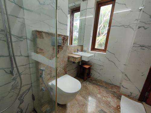 a bathroom with a toilet and a shower and a sink at Capital Hotel in Mumbai