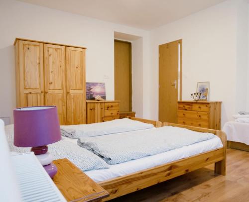 a bedroom with a bed and a table with a lamp at Hostinec Klopoty in Říčky