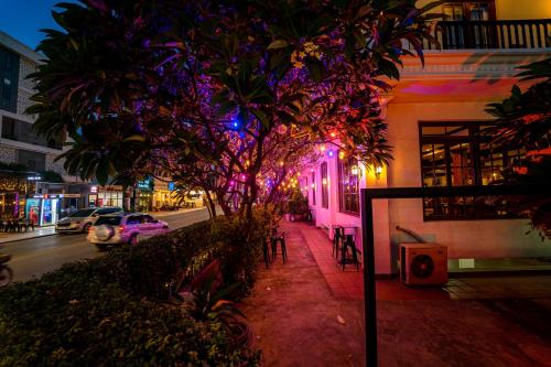 a city street at night with a tree and lights at The Suite By Royal Crown Hotel in Siem Reap