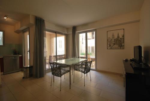 une salle à manger avec une table et des chaises en verre dans l'établissement Vieux Port One Bedroom Apartment A05, à Cannes