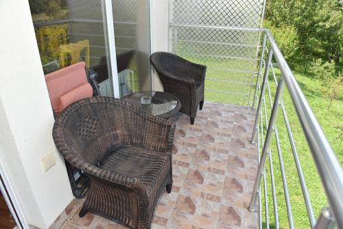 a patio with two chairs and a table on a balcony at Vidikovac pod Jelicom in Čačak