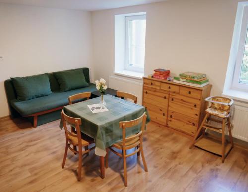 a living room with a table and a couch at Hostinec Klopoty in Říčky