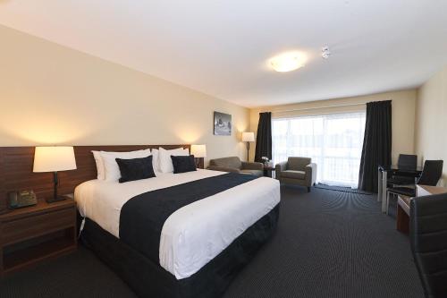 a hotel room with a large bed and a large window at Newina Rotorua in Rotorua