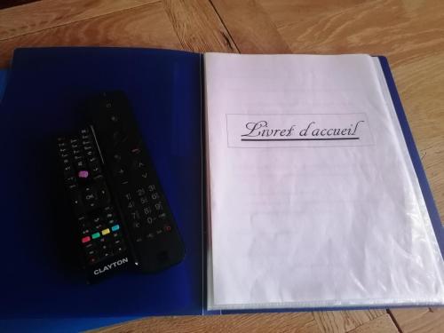 a remote control sitting on top of a book at chez Marie et Lulu in Dompierre-sur-Nièvre