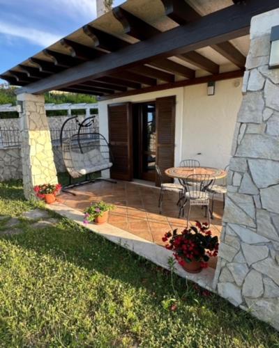 a patio with a table and chairs and a stone wall at CASA VACANZA FELICITA' in Porto Potenza Picena