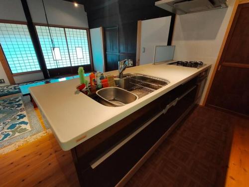 a kitchen with a sink and a counter top at ファミリー向けの一棟貸切り別荘「セキデンファーム」 in Warao