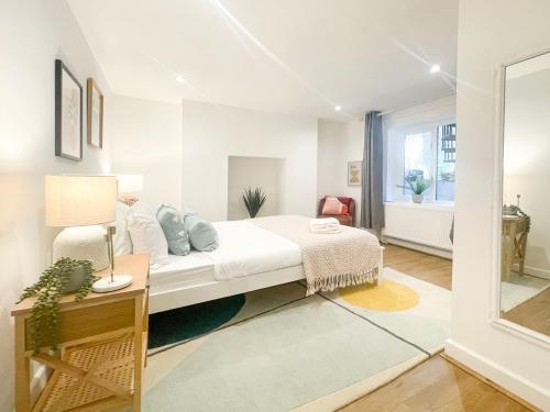 ein weißes Schlafzimmer mit einem Bett und einem Schreibtisch in der Unterkunft Sweet&Stylish 1 bed flat in CamdenTown in London