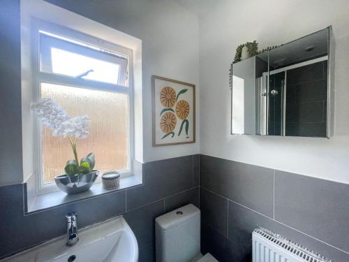 ein Bad mit einem WC, einem Fenster und einem Waschbecken in der Unterkunft Sweet&Stylish 1 bed flat in CamdenTown in London