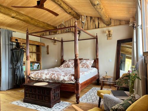 - une chambre avec un lit à baldaquin dans une cabine dans l'établissement Les Magnels, à Valleraugue