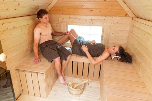 three people sitting on the inside of a sauna at Chalet VitaSpa - Whirlpool & Sauna PrivatSpa in Pegnitz