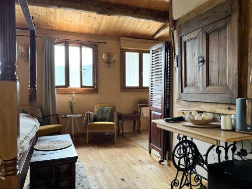 Cette chambre comprend un lit, une table et des fenêtres. dans l'établissement Les Magnels, à Valleraugue