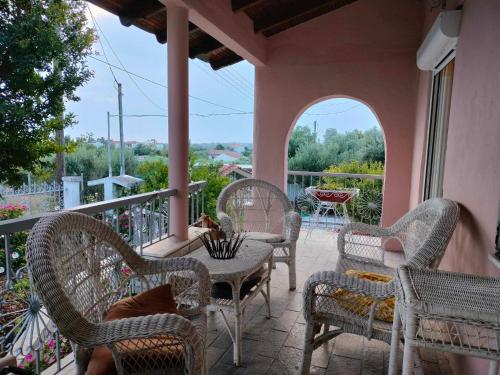 a patio with wicker chairs and tables on a balcony at kali SunnySide Up in Nea Kalikratia