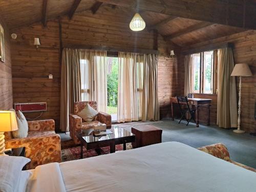 a bedroom with a bed and a living room at The Heritage Club - Tripura Castle Hotel and Spa in Shillong