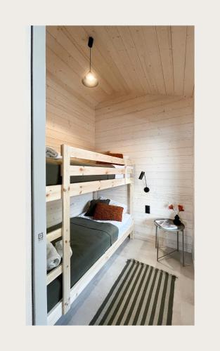 a bedroom with two bunk beds and a table at Domy na wodzie Sztynort in Sztynort