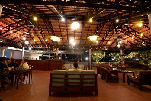 a restaurant with people sitting at tables in a building at Royal Crown Hotel & Spa in Siem Reap