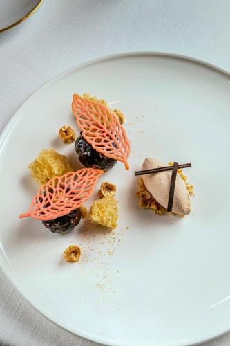 a white plate with some food on it at The Reverie Saigon Residential Suites in Ho Chi Minh City
