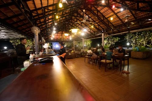 a bar with people sitting at tables in a restaurant at Royal Crown Hotel & Spa in Siem Reap