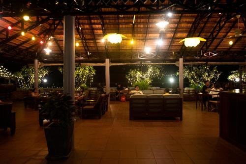a restaurant with people sitting at tables at night at Royal Crown Hotel & Spa in Siem Reap