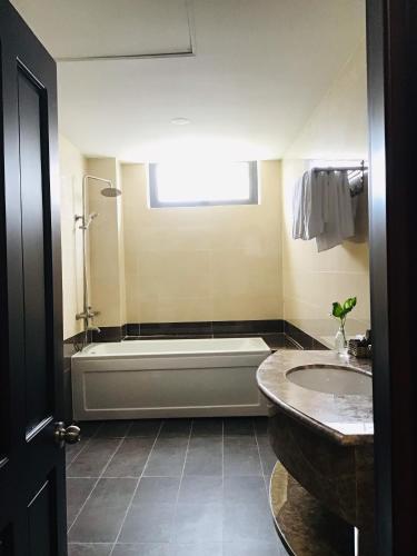 a bathroom with a tub and a sink at Quê Tôi Hotel in Soc Trang