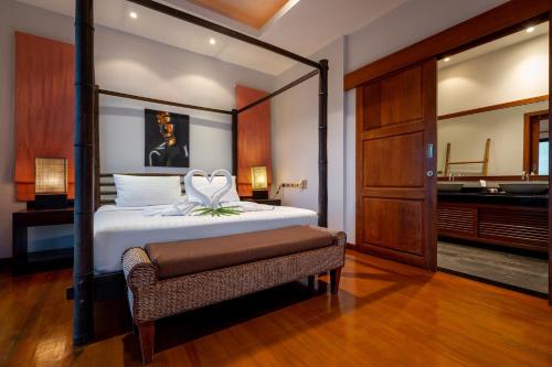 a bedroom with a large bed and a bathroom at Villa Baan Saitara in Lamai