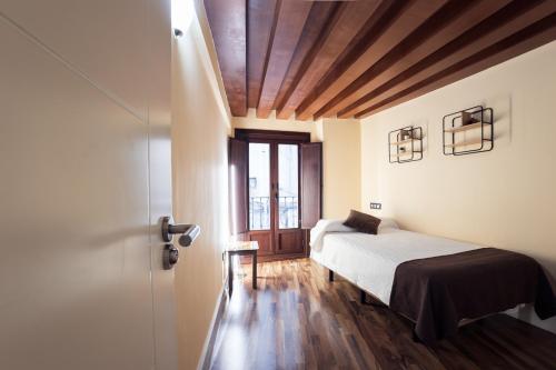 a bedroom with a bed and a window and a door at HERMOSA 7 in Granada