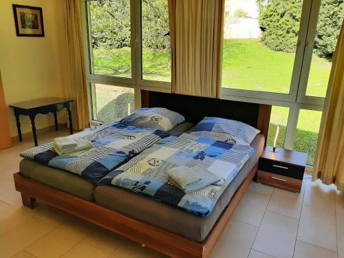 a bed in a room with a large window at Schloss Thorn in Palzem