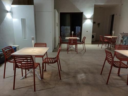 a dining room with tables and chairs and lights at Appartamento Nonna Lina in Custonaci